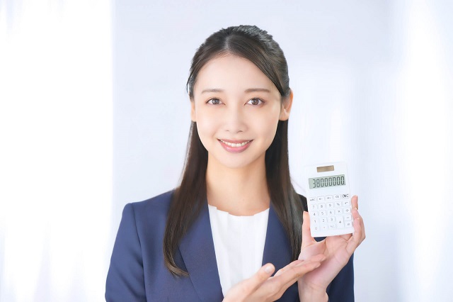 電卓を手に持つ人物