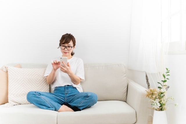 薄毛治療についてスマートフォンで調べる様子